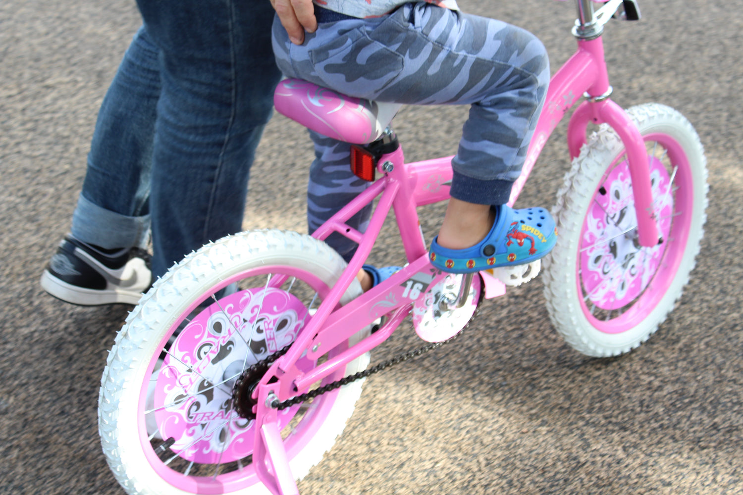 A parent guiding a child learning to ride a bike, demonstrating balance and support.